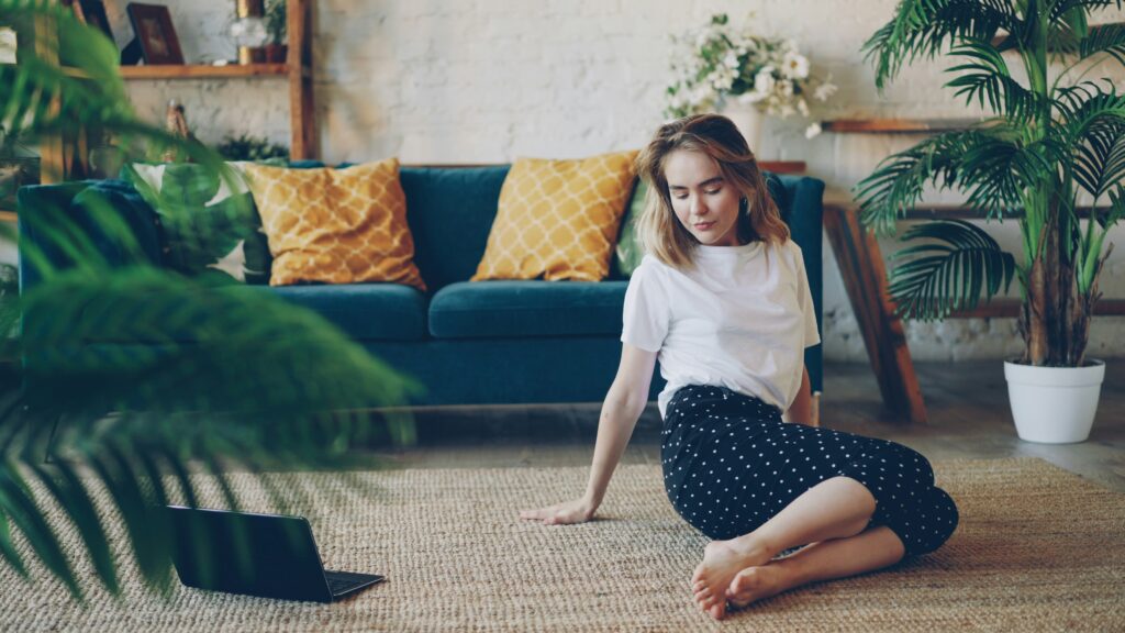 Woman practising morning yoga at home in soft sunlight, representing financial freedom and a life lived on your own terms